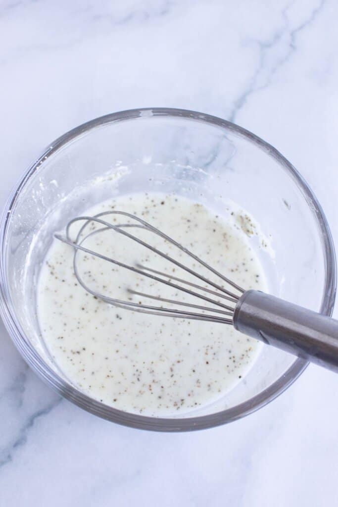 Cornstarch slurry being mixed in a bowl.