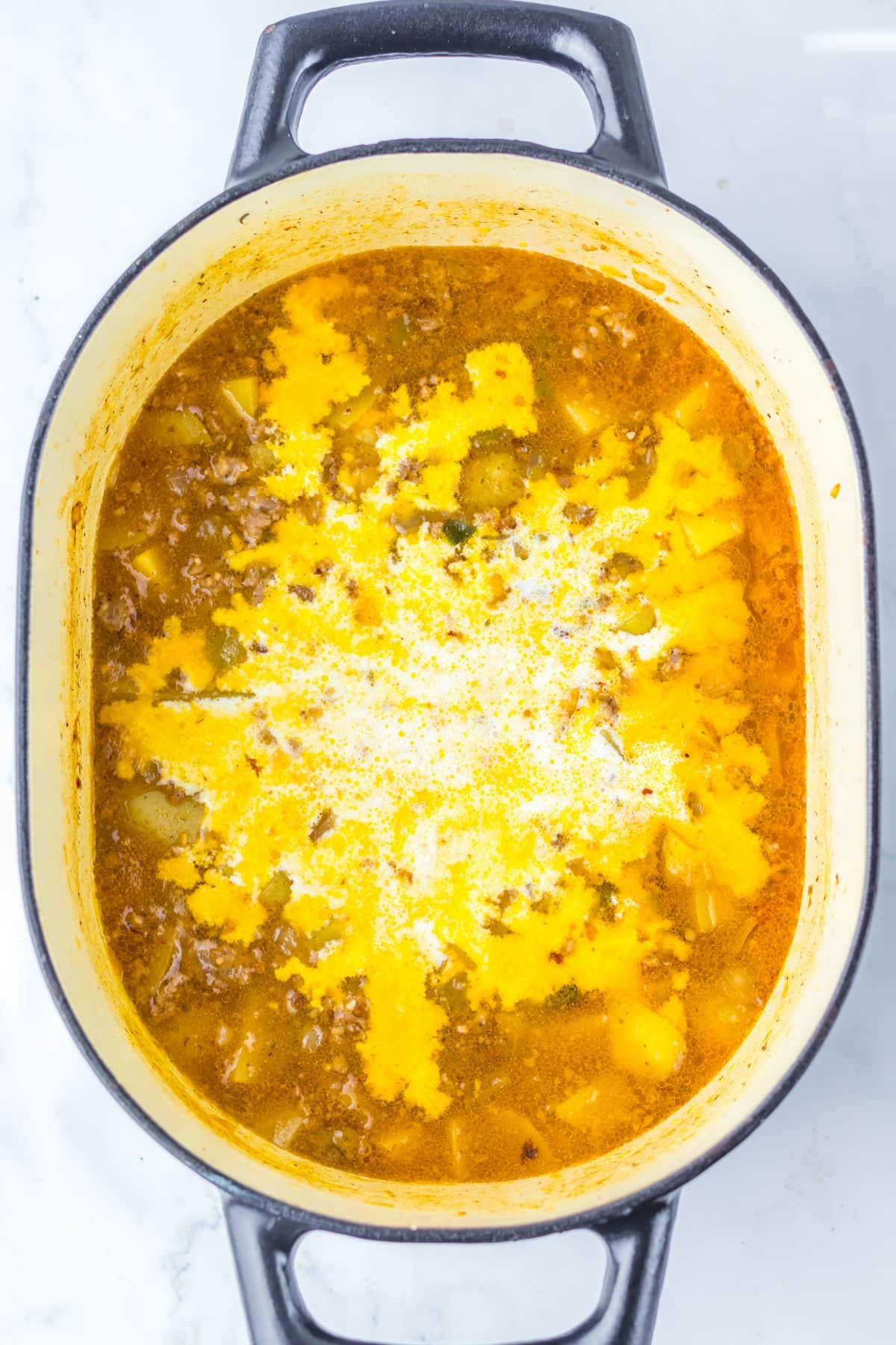 Cream being added to a pot of soup.
