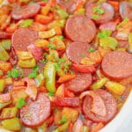 Baking dish full of kielbasa and vegetables.