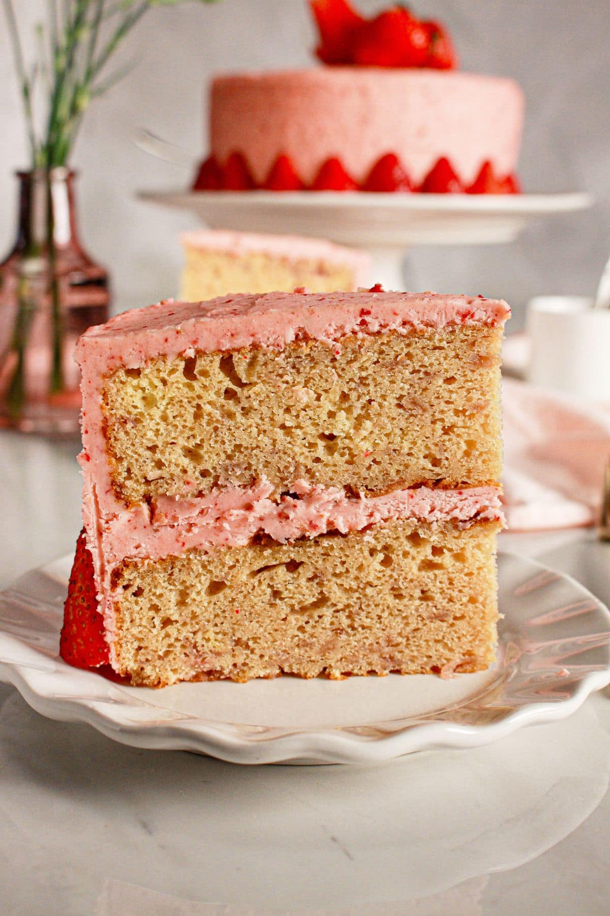 Slice of strawberry cream cake on a plate.