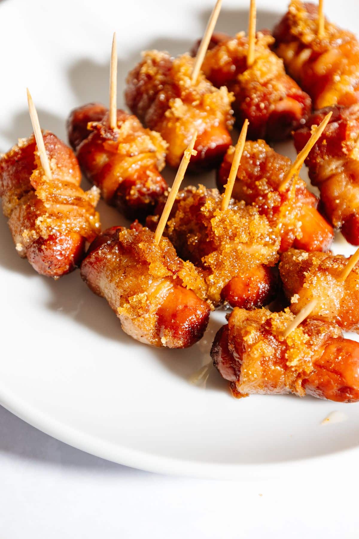Bacon wrapped little smokies on a plate.