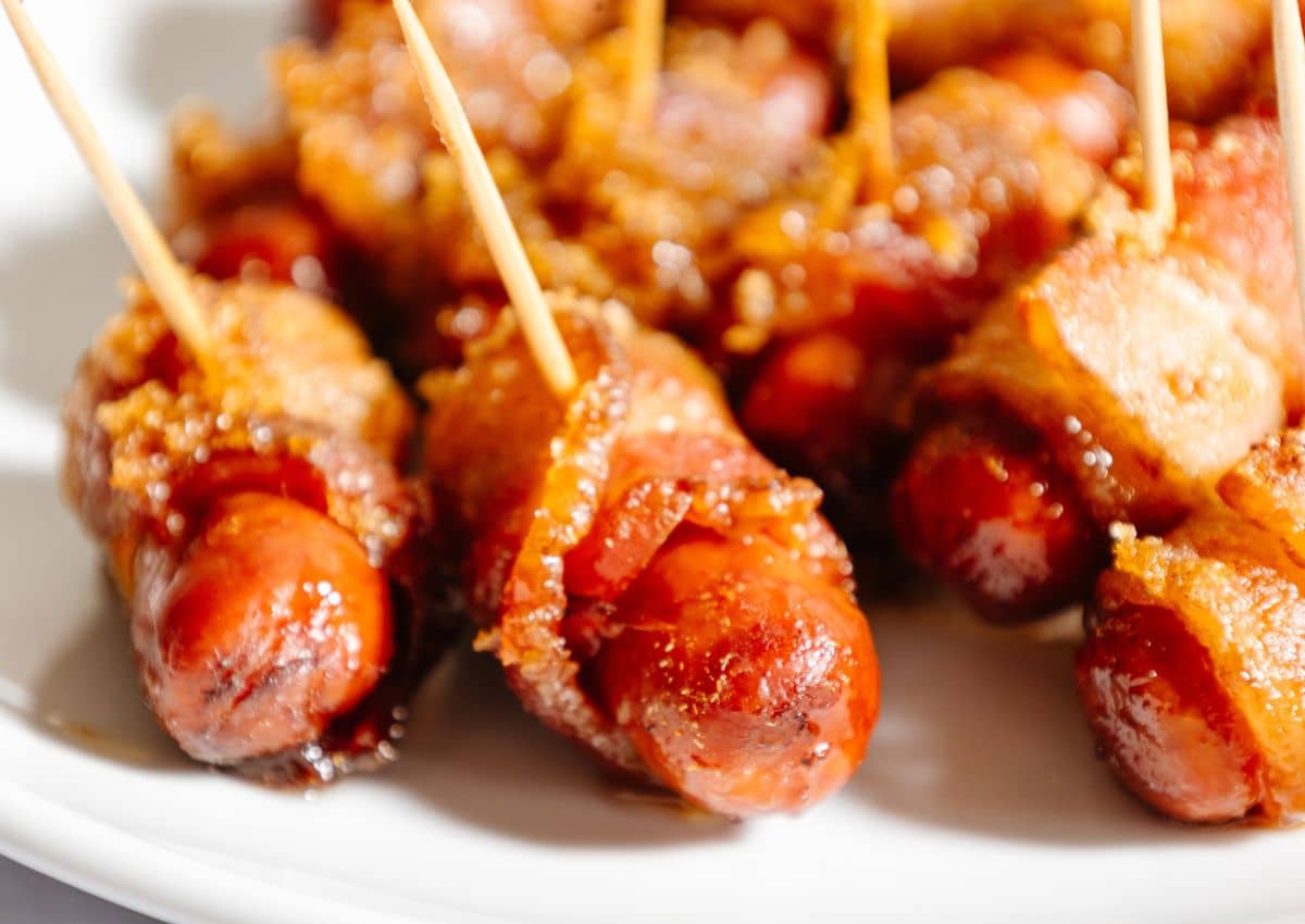 Bacon wrapped little smokies on a plate.
