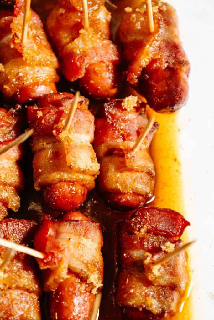 Bacon wrapped little smokies in a baking dish.