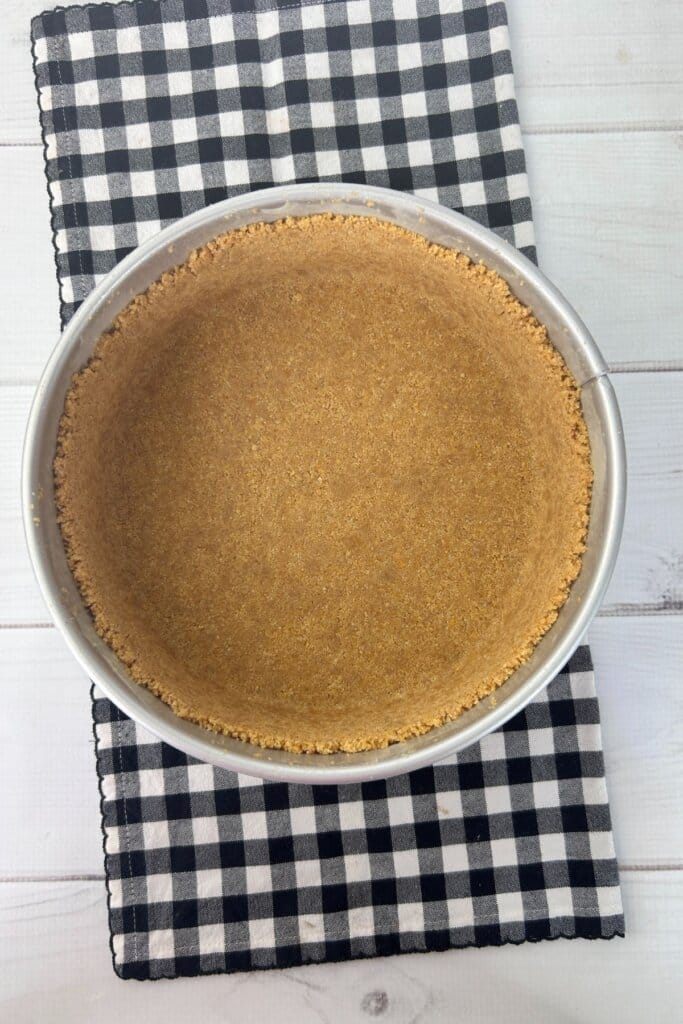 Crust being pressed into a spring form pan.