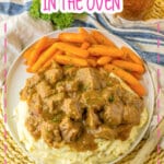 Beef tips on a plate on top of a bed of mashed potatoes.