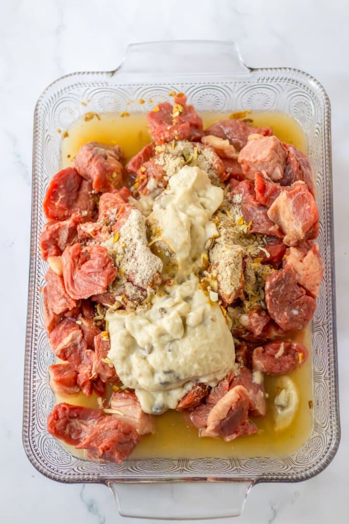 Stew meat, onion soup, and cream of mushroom in a baking dish.