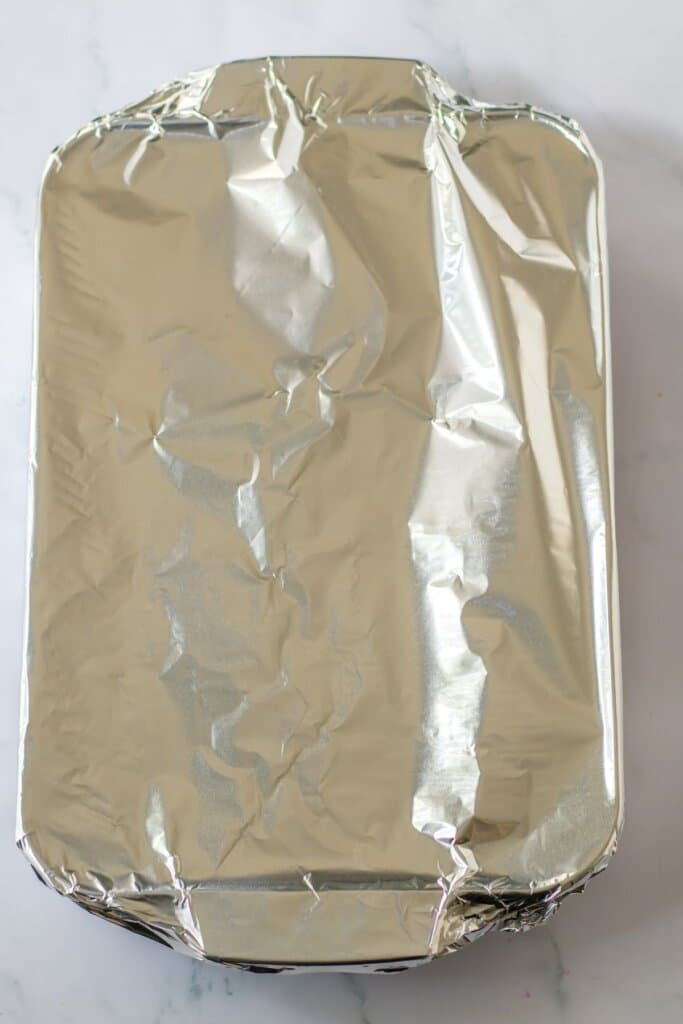 Glass baking dish covered with foil.