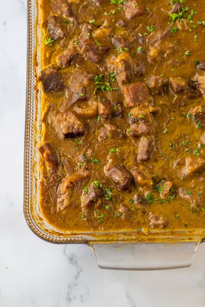 Glass baking dish full of beef tips and gravy.