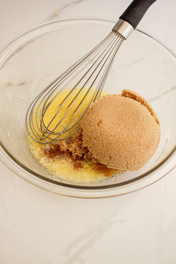 Brown sugar and melted butter being mixed in a large bowl.