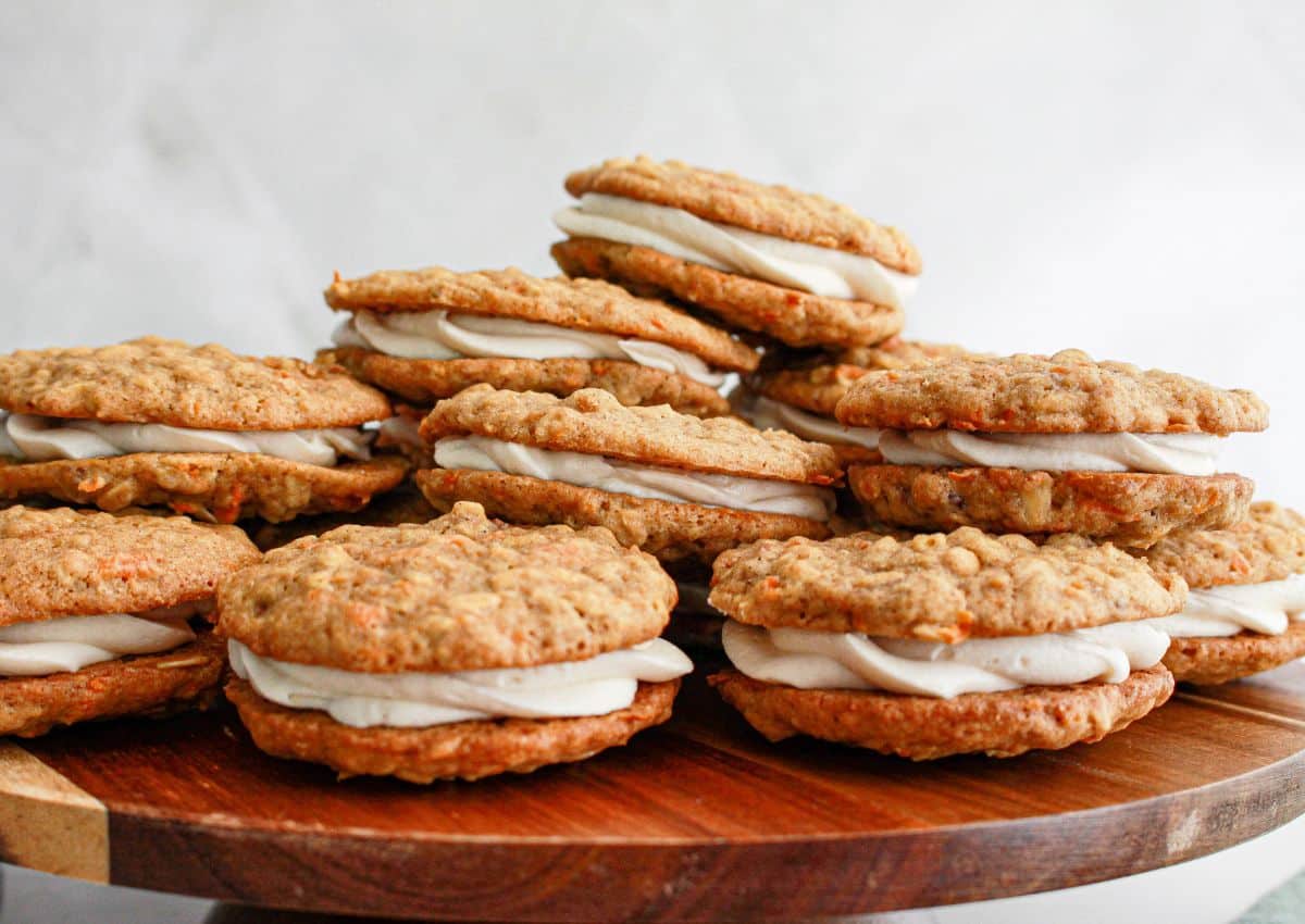 Carrot cake sandwich cookies on a cutting board.