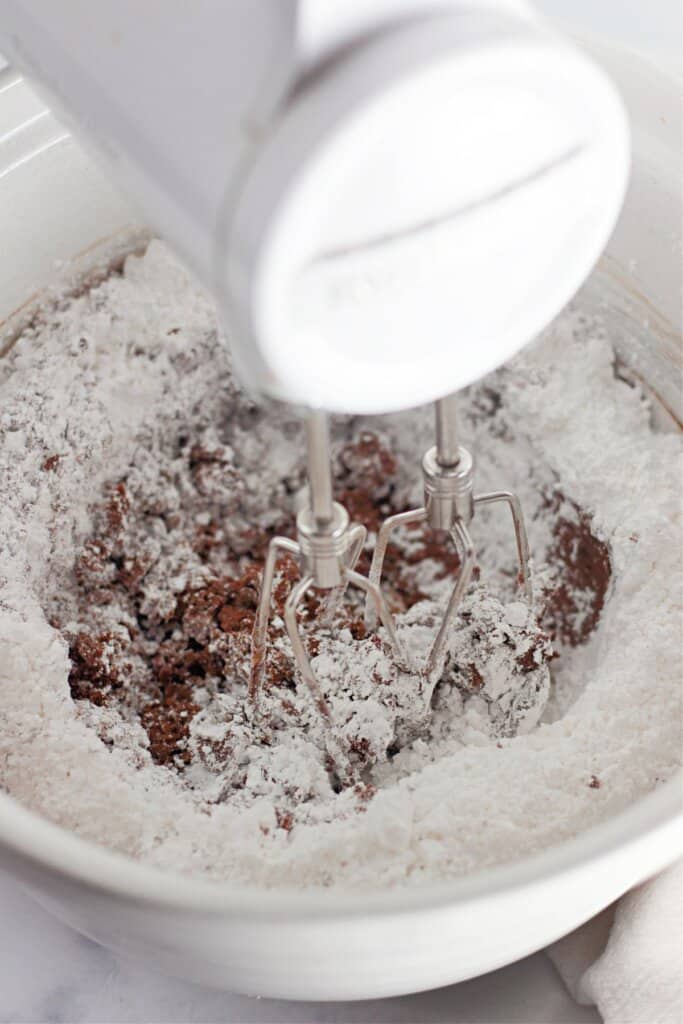 Powdered sugar being mixed into frosting.