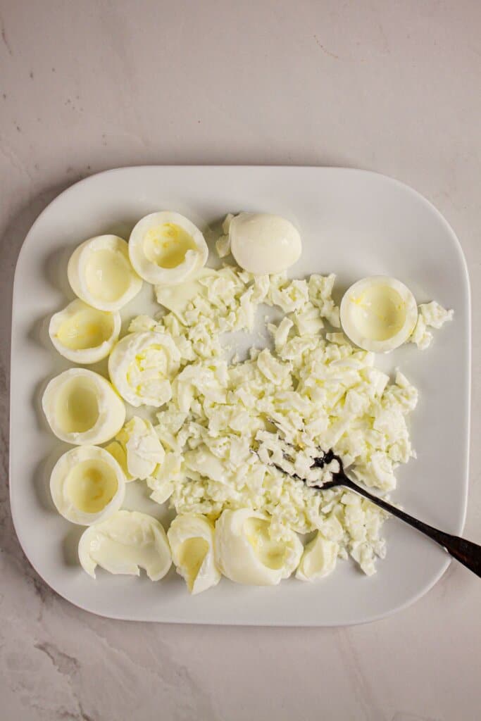 Whites being smashed with a fork on a plate.