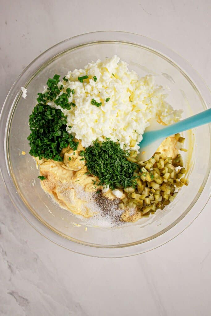 Ingredients being mixed together in a large glass bowl.