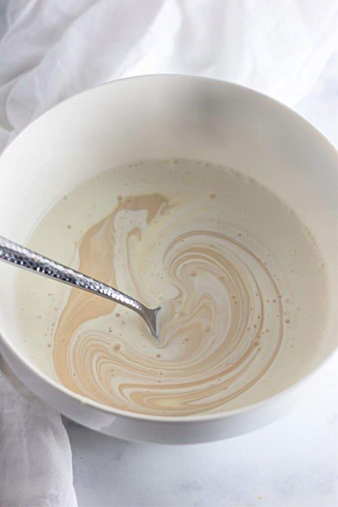 Condensed milk being mixed in a bowl.
