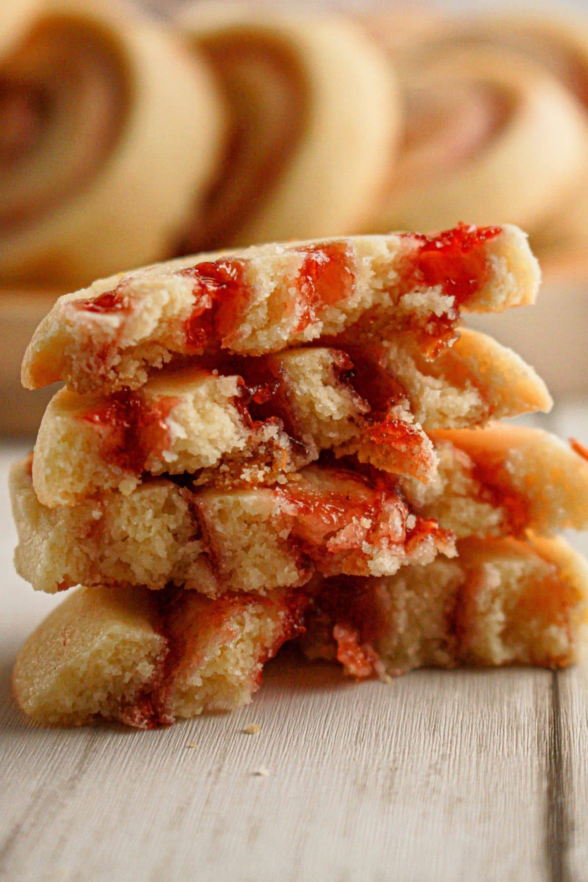 Two raspberry lemon cookies broken and half and stacked on top of each other.