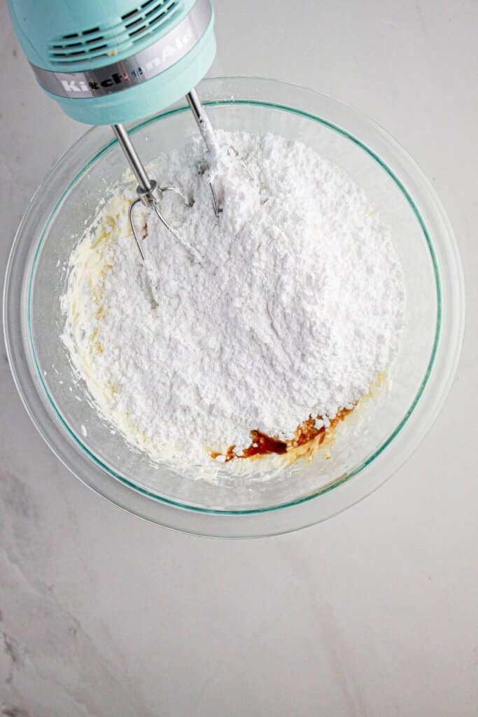Butter, powdered sugar, and vanilla in a glass bowl.