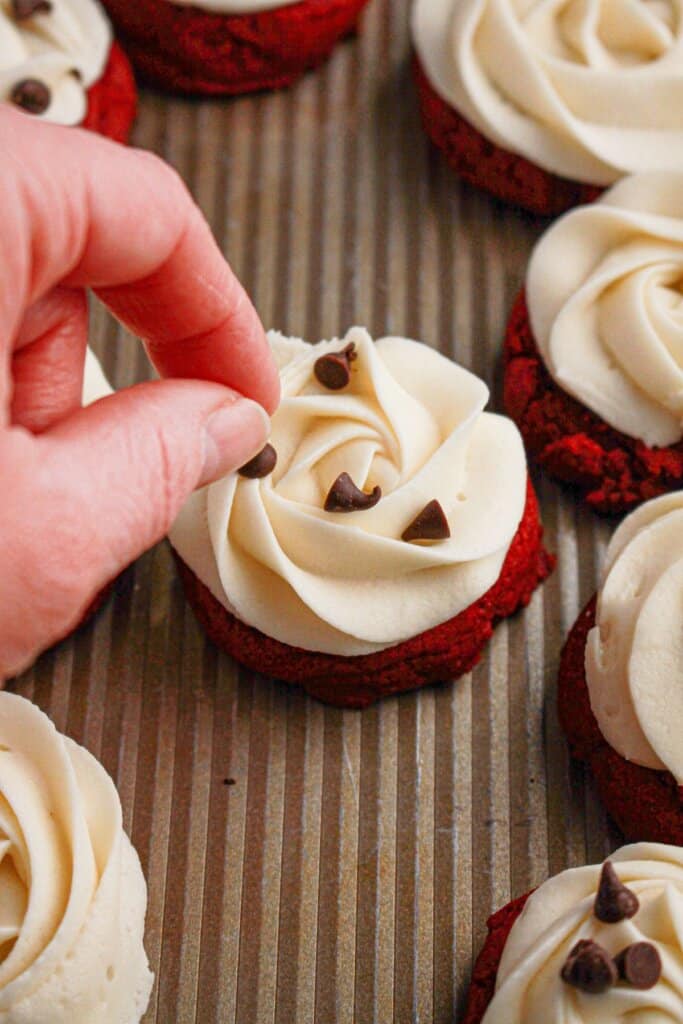 Chocolate chips being added to cookies.