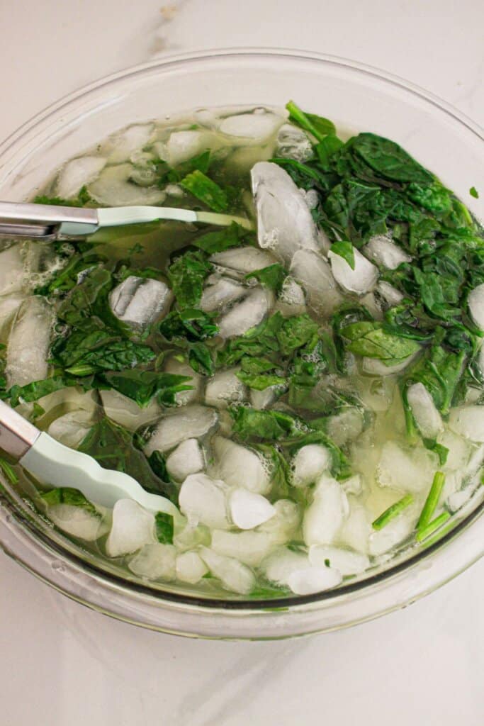 Spinach being cooled in an ice bath.