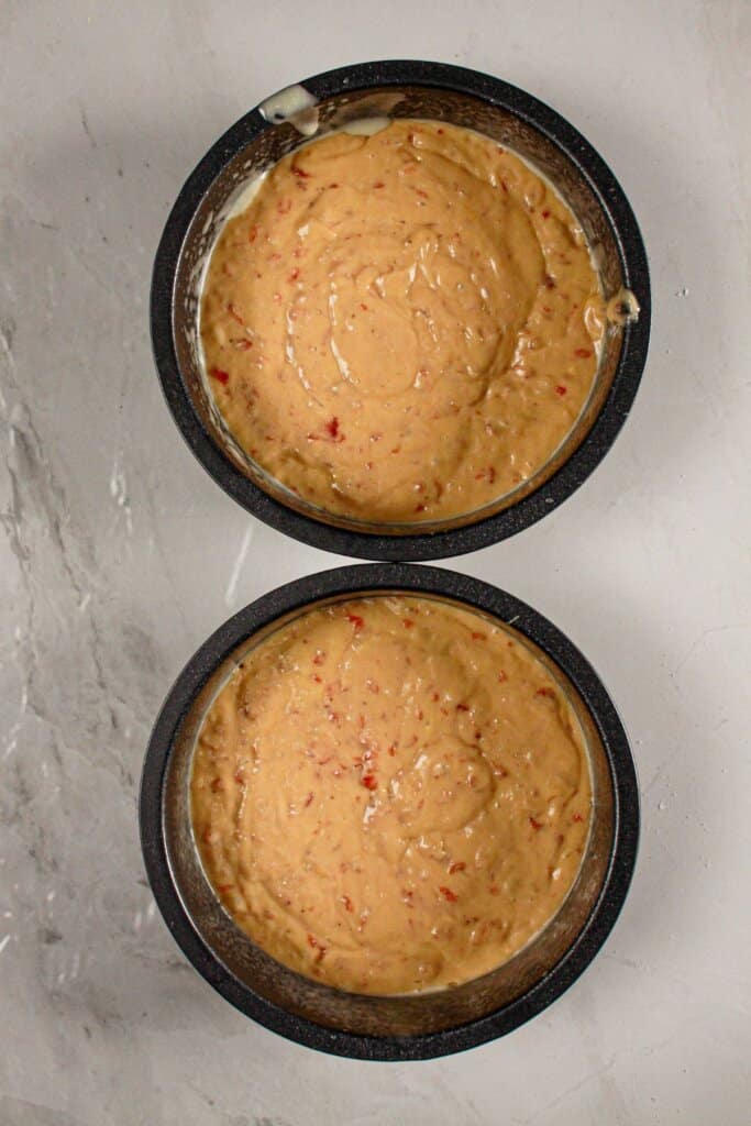 Cake batter in two round cake pans.