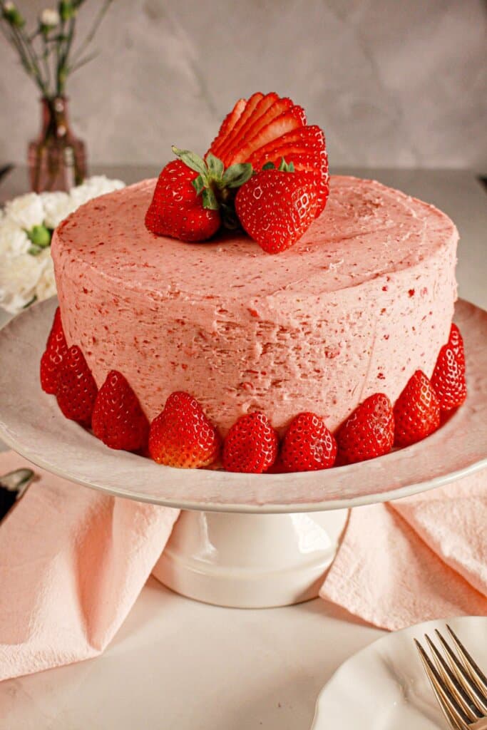 Strawberry cream cake on a cake stand.