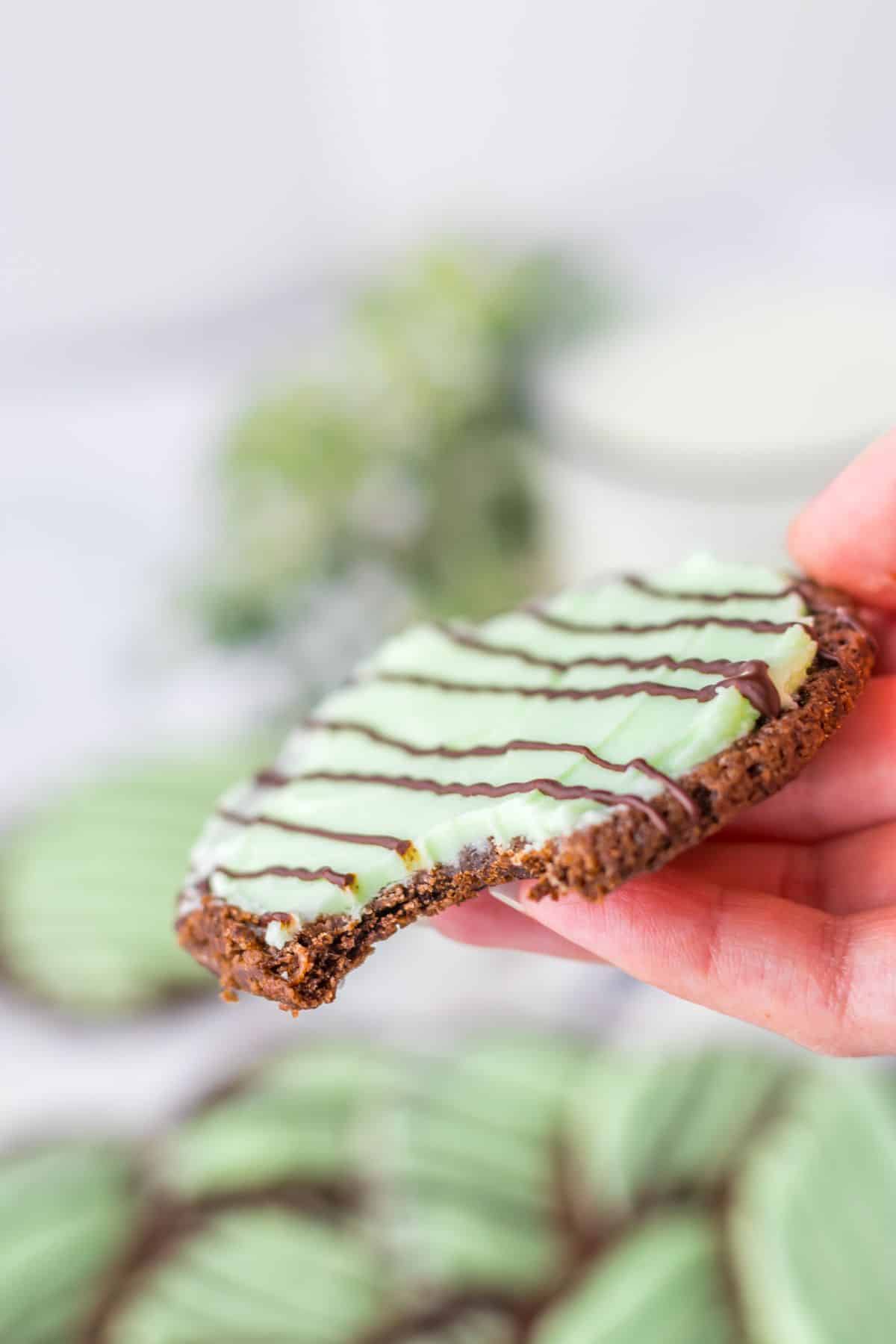 Thin mint cookie held in a women's hand.