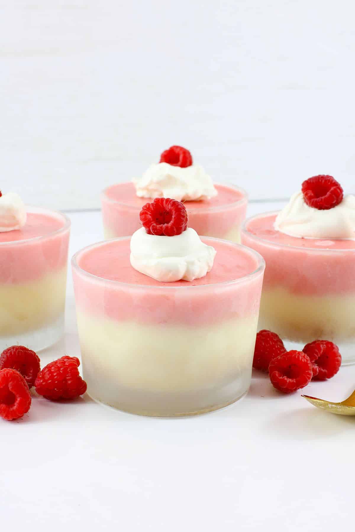 Raspberry prosecco cheesecake cups on a counter.