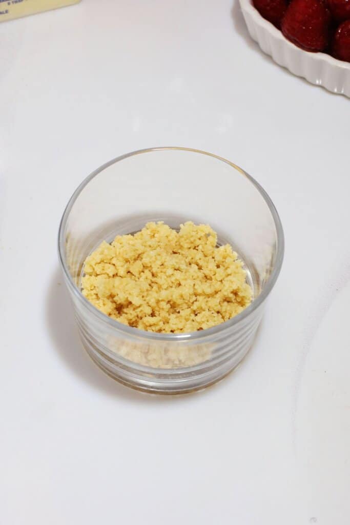 Graham crackers crumbs in a small glass.