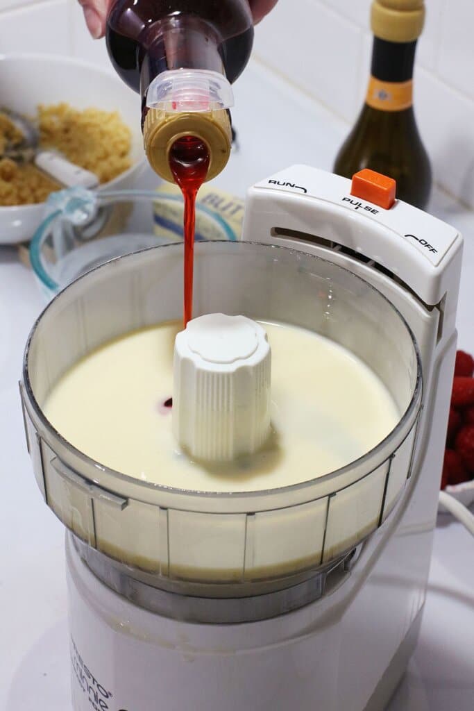 Raspberry syrup being added to cheesecake filling.