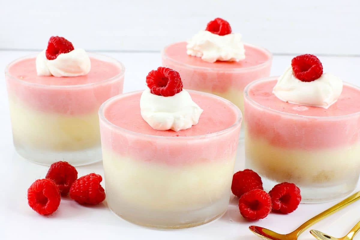 Raspberry prosecco cheesecake cups on a counter.