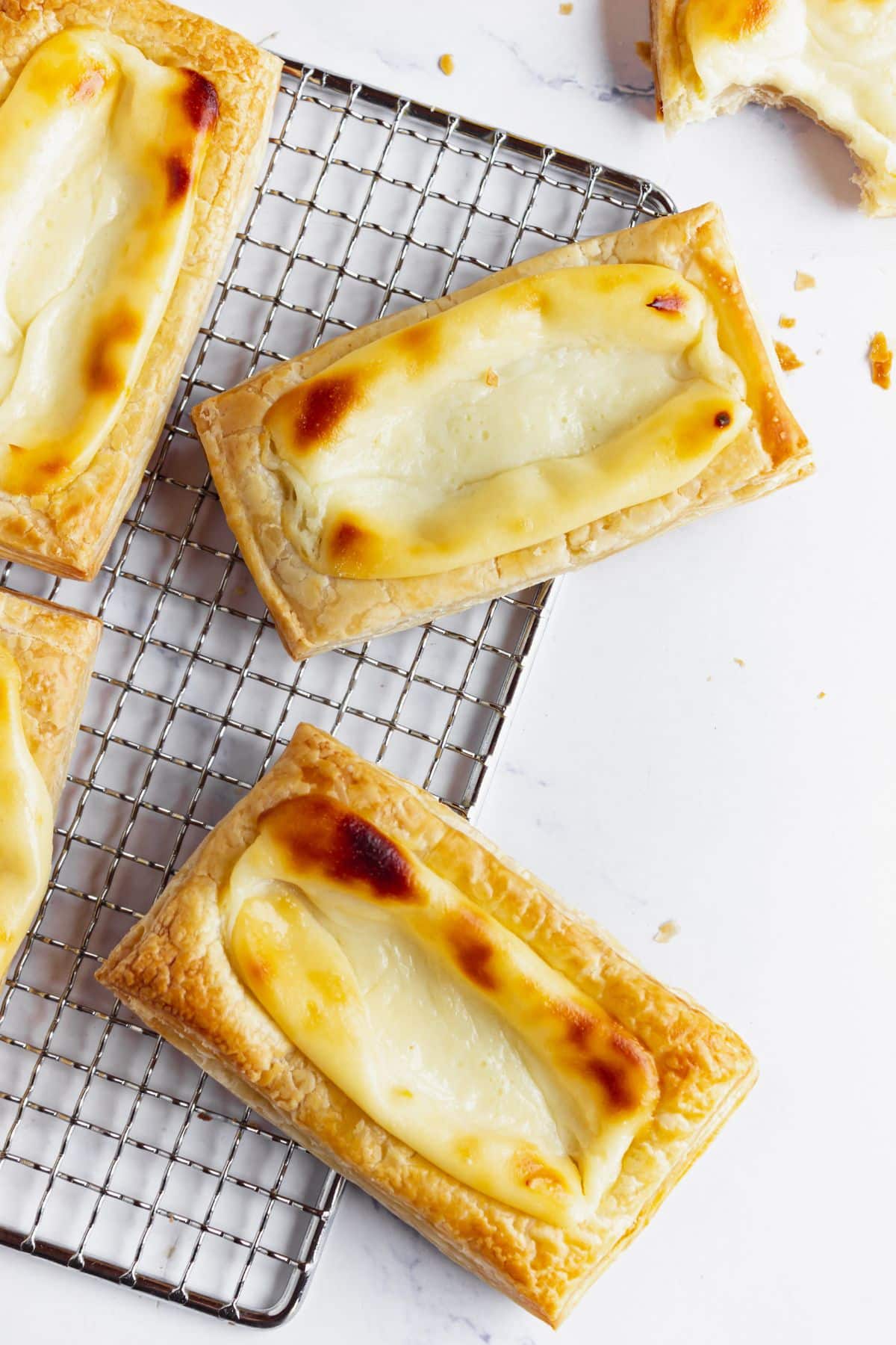 Four starbucks cheese danishes on a wire rack.