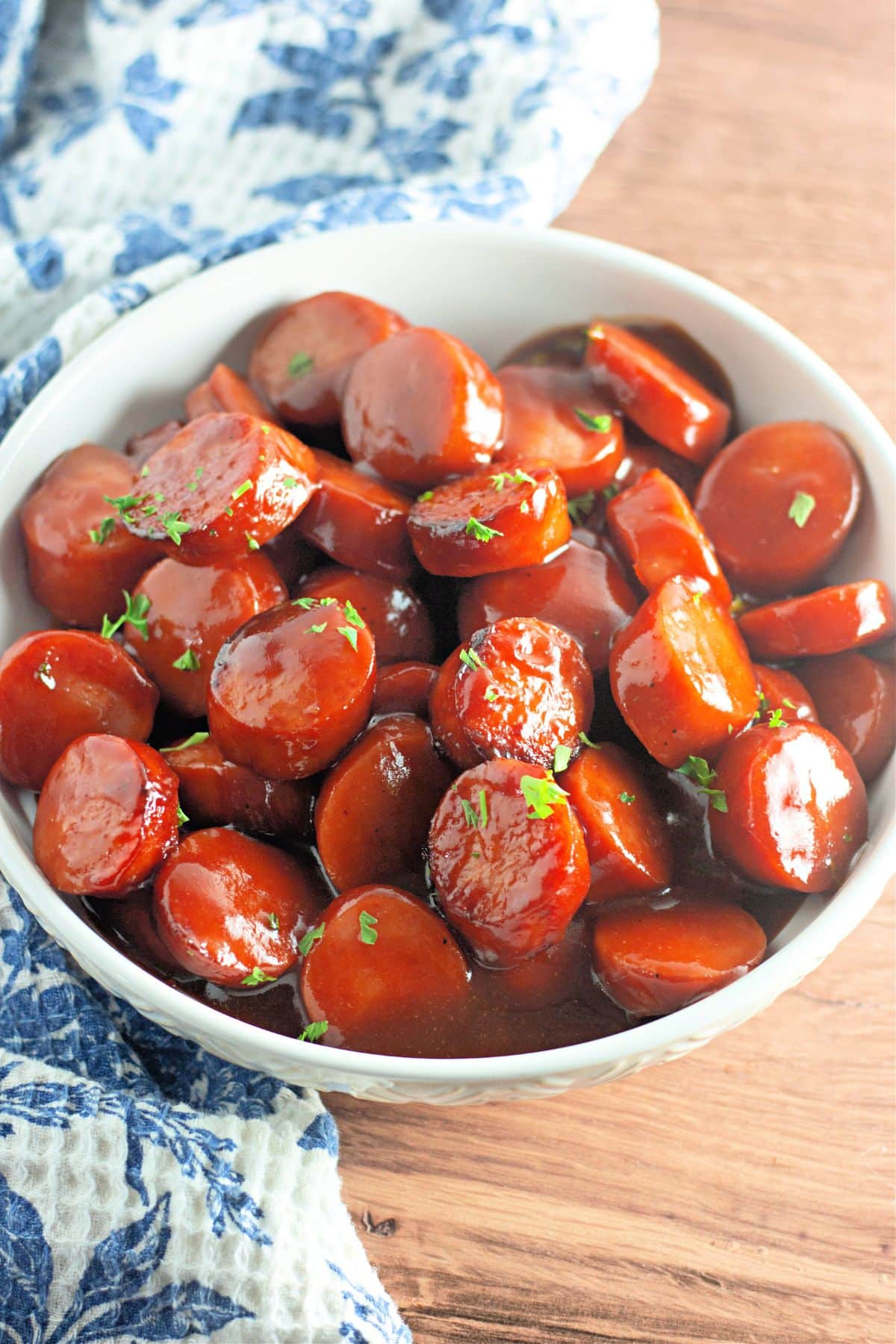 White bowl full of baked bbq kielbasa.
