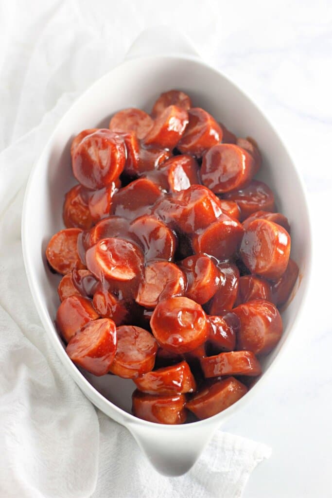 Smoked sausage in barbecue sauce in a casserole dish.