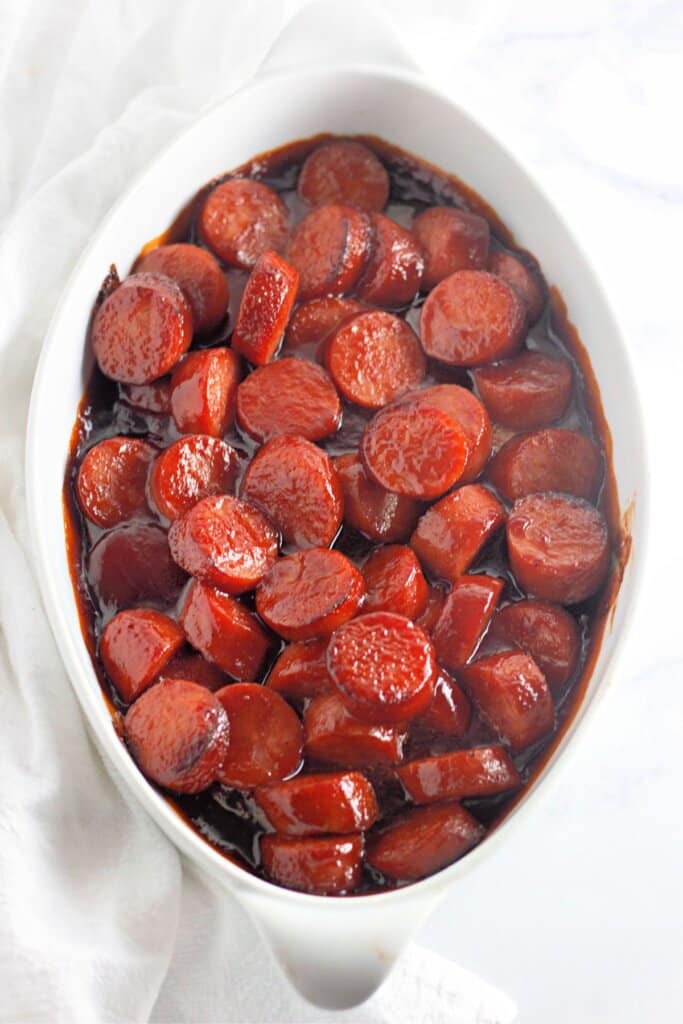 Baked kielbasa in a white casserole dish.