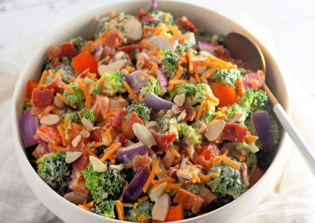 White bowl full of broccoli salad.
