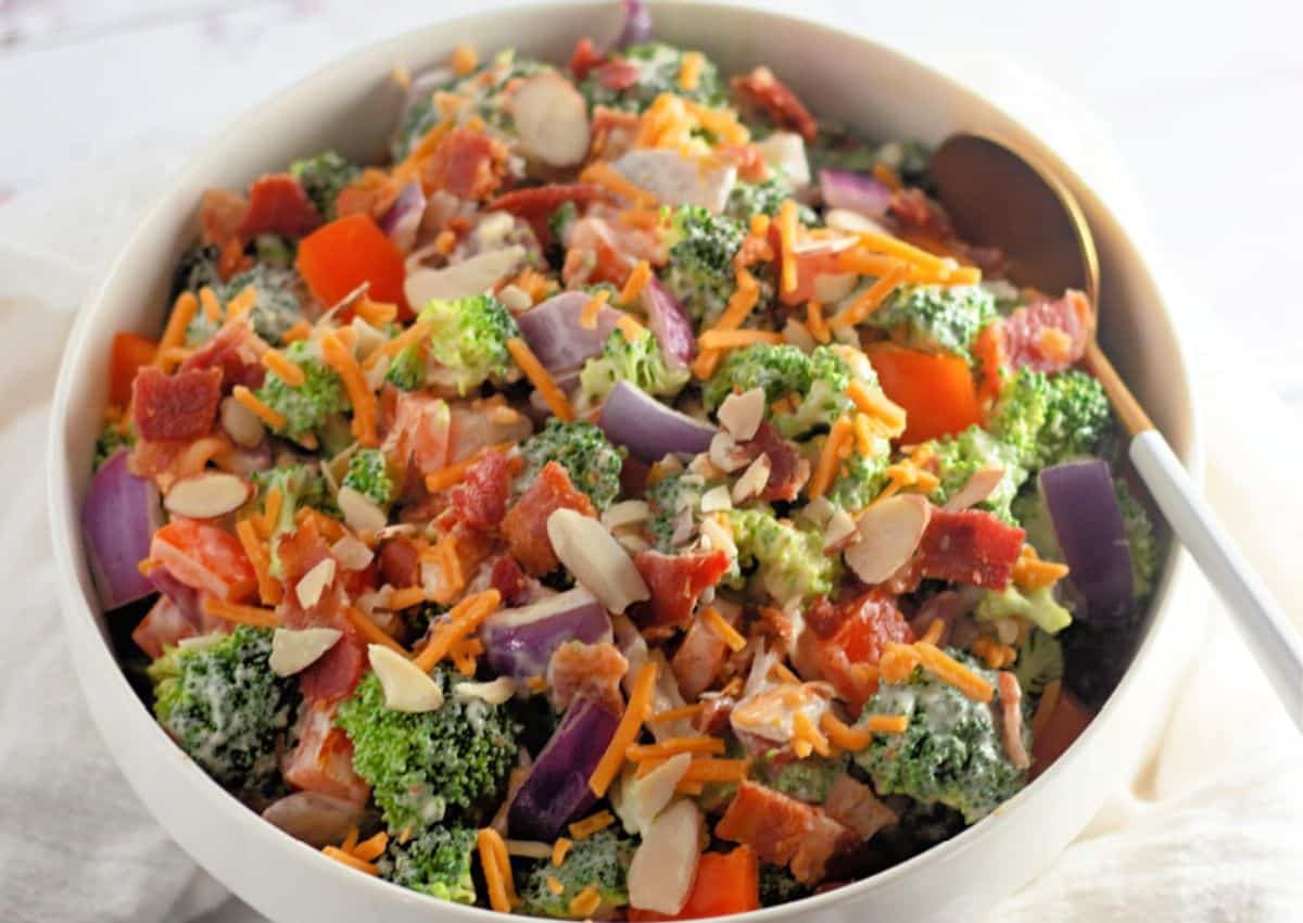White bowl full of broccoli salad.