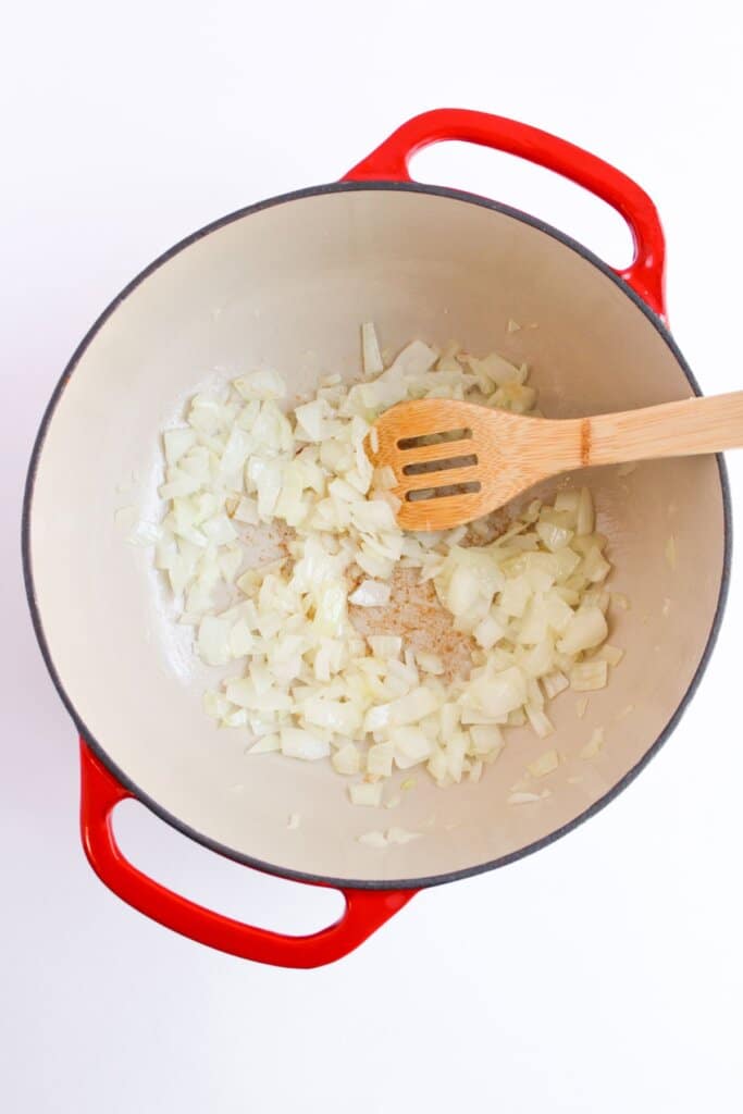 Onions being cooked in a large pot.