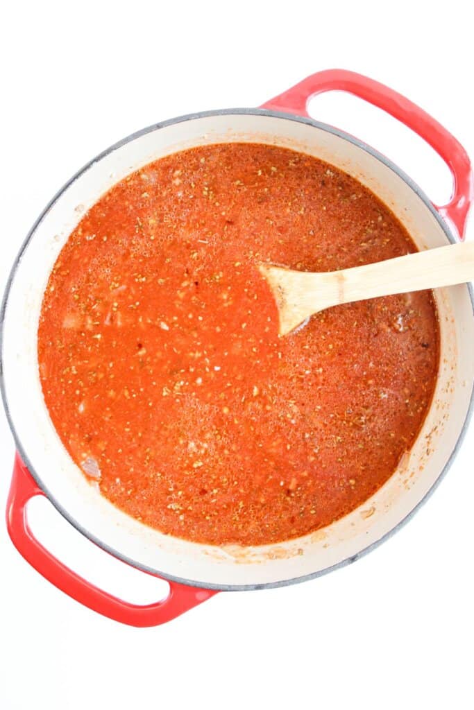 Meat, sauce, and seasonings being cooked in a large pot.