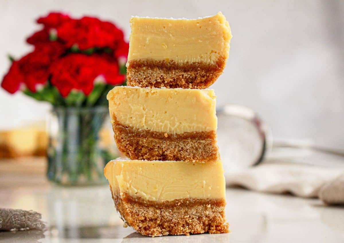 A stack of three lemon bars on a counter.