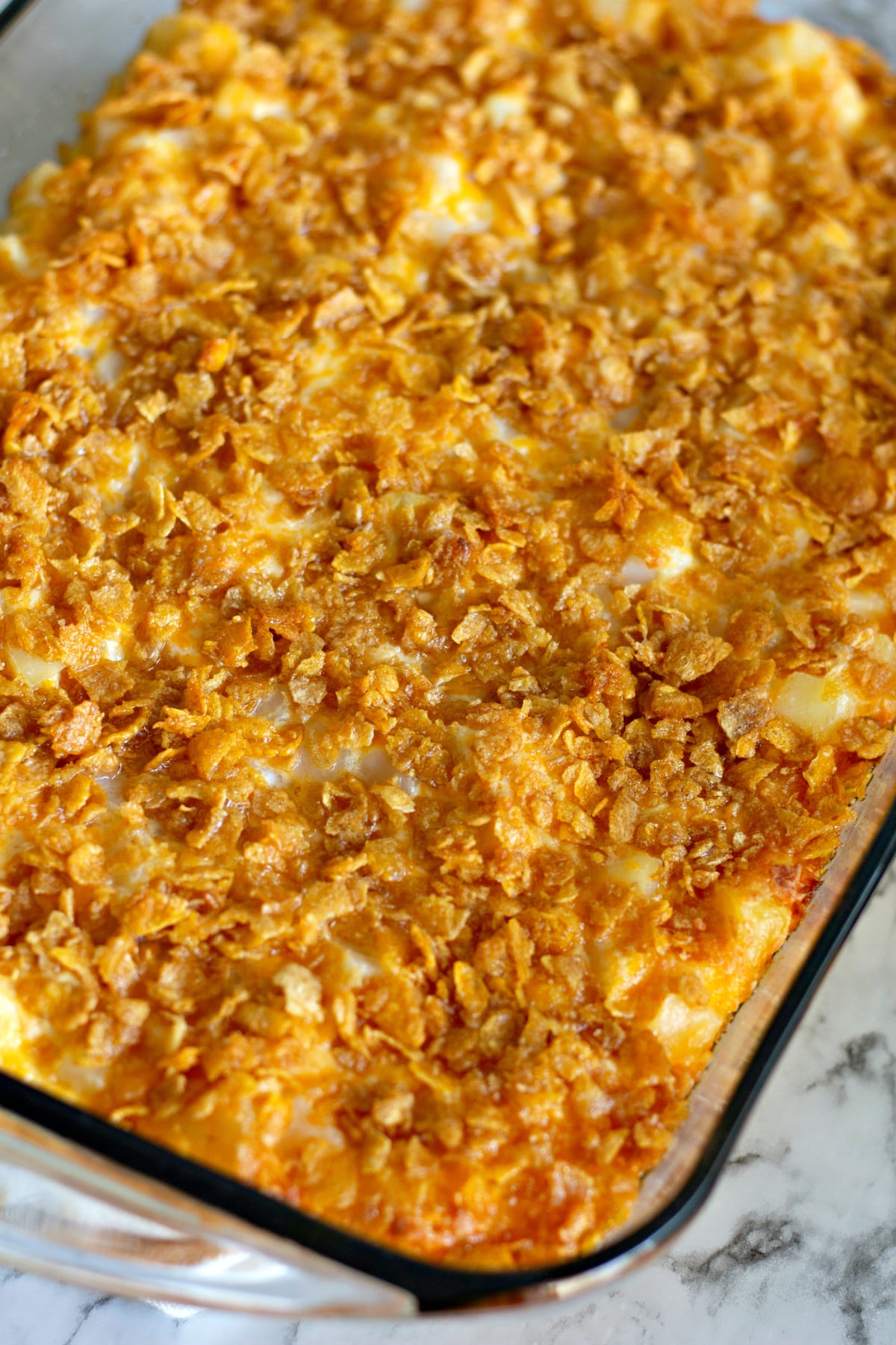 Funeral potatoes in a glass baking dish.