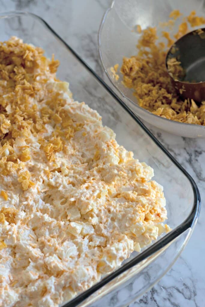 Topping being added on top of a casserole.