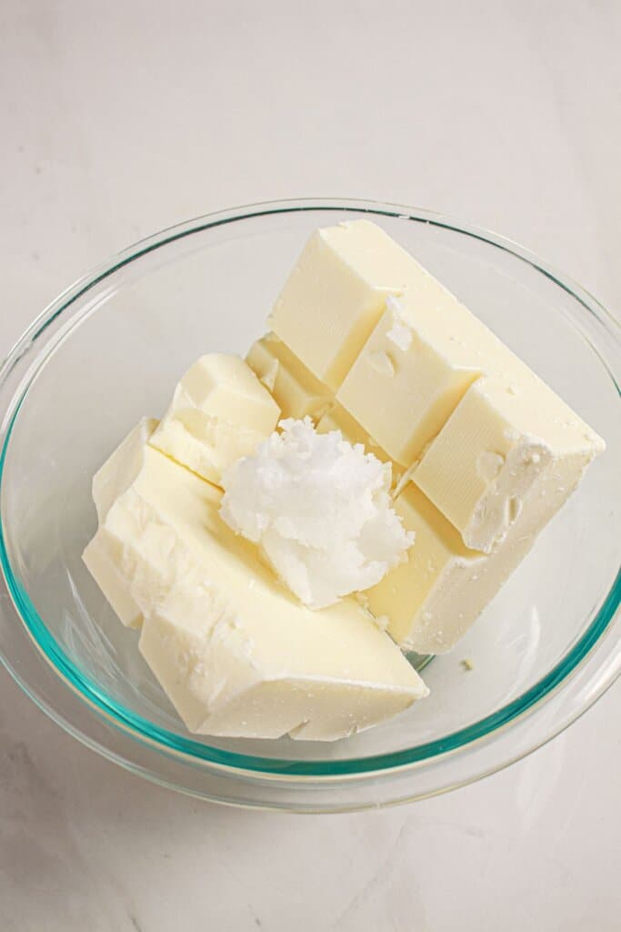 Almond bark and coconut oil in a glass mixing bowl.