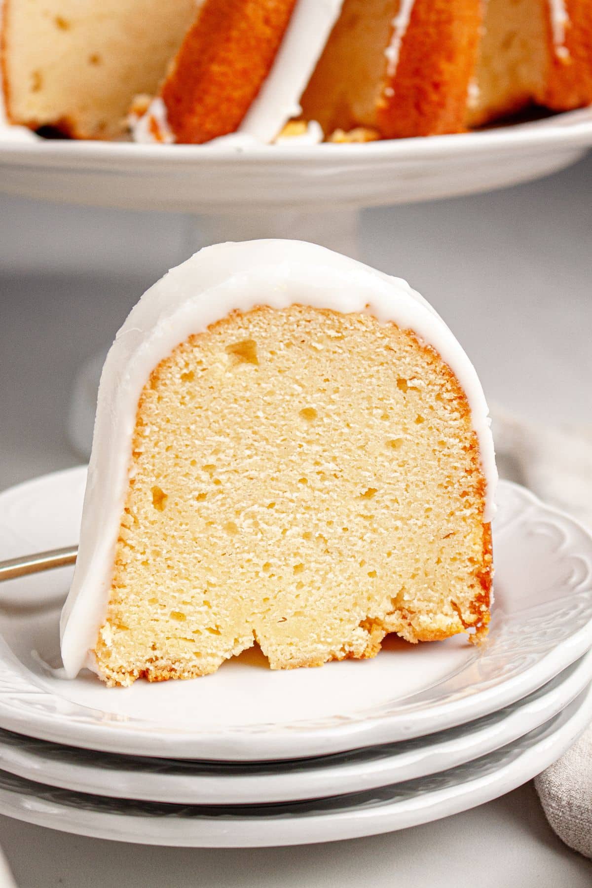Slice of lemon bundt cake on a plate.