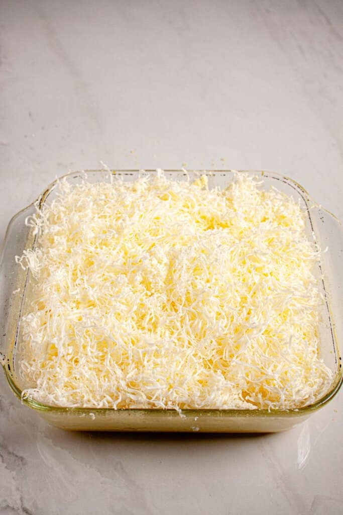 Butter grated on top of a casserole dish.