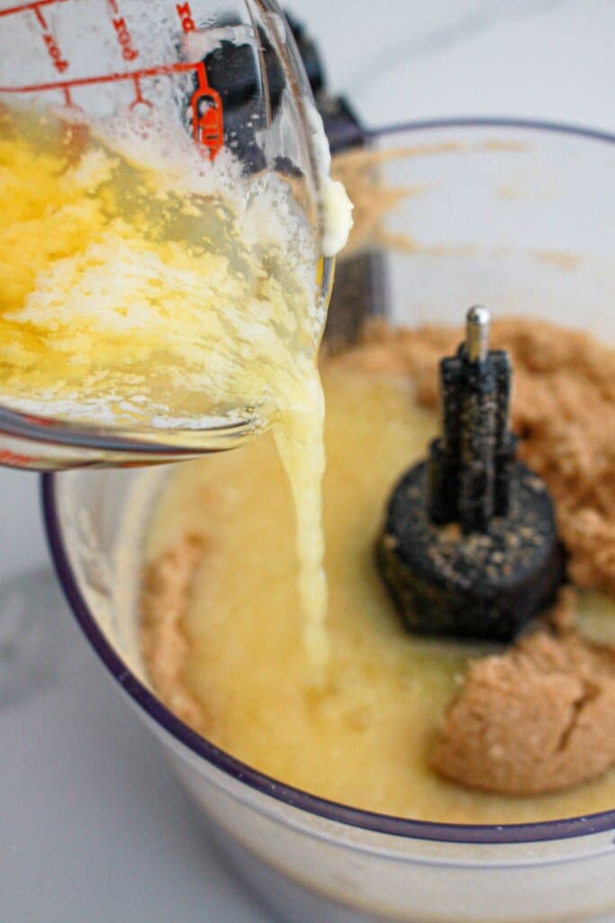 Melted butter being poured into a food processor.