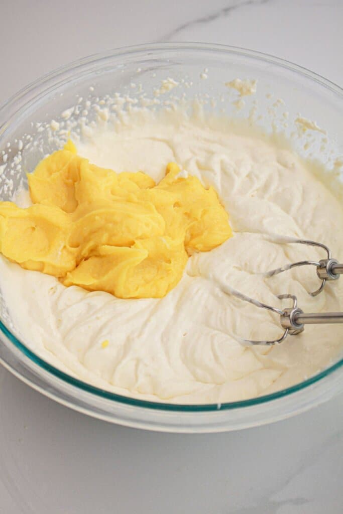 Curd being added to filling in a glass bowl.