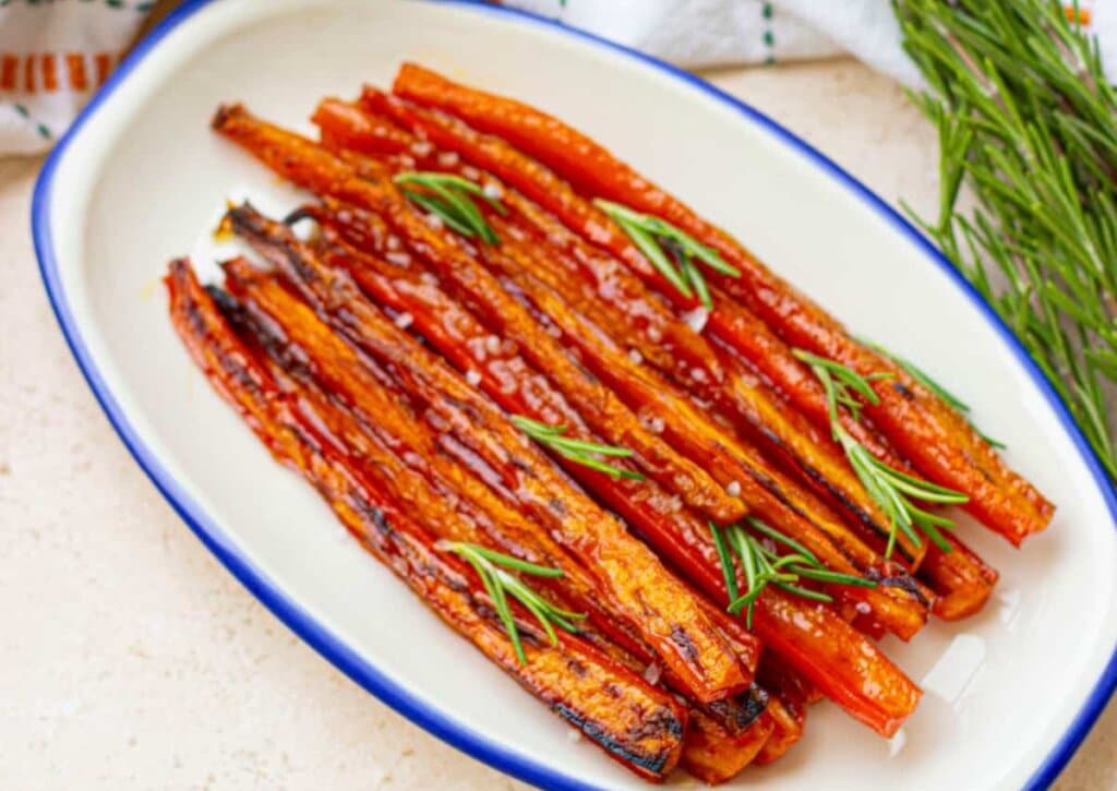 Maple glazed carrots in a white serving dish.
