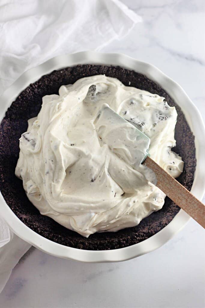 Oreo filling being spread into a pie.