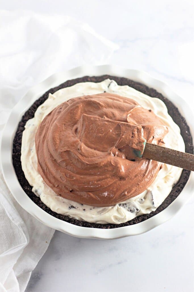 Chocolate pudding being spread on top of a pie.