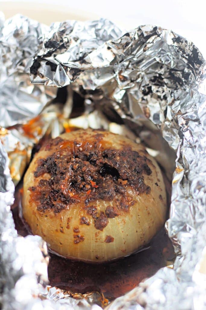 Cooked onion wrapped in aluminum foil.