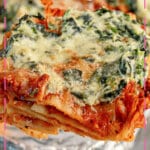 Slice of sheet pan lasagna being removed from the pan.